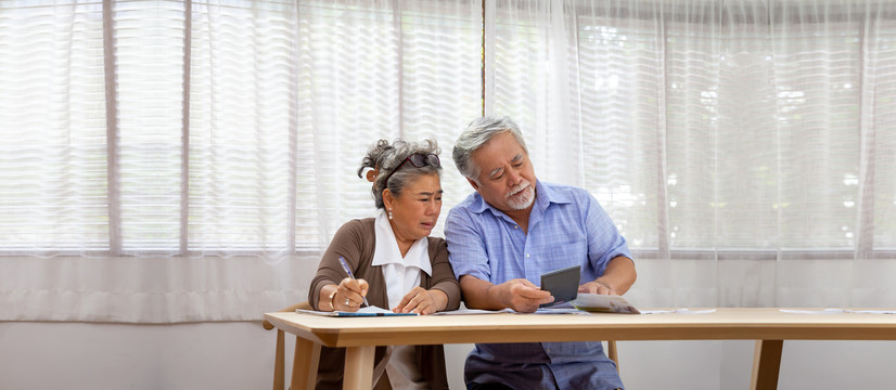 亚洲老年夫妇严重担心计算每月的账单或债务，退休老人阅读贷款文件，金钱问题的概念