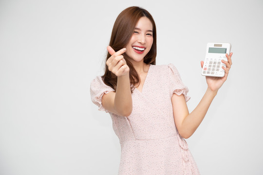 激动的亚洲女性手持计算器的肖像，背景为白色，商业和金融概念