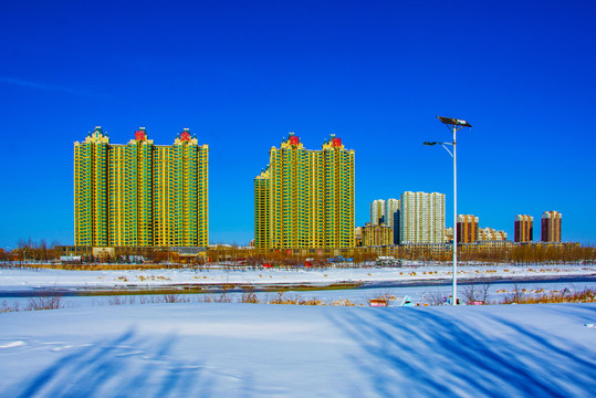 高层住宅建筑群与雪地河道远景
