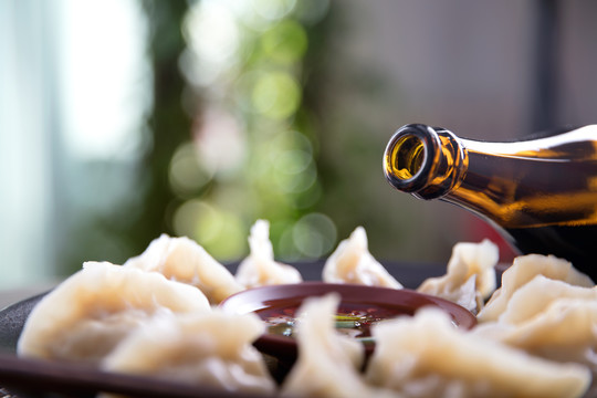 一盘中国传统美食饺子和醋瓶子