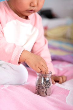 中国小女孩正把美元硬币装入玻璃
