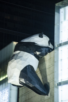成都春熙路高楼上的大熊猫爬雕塑