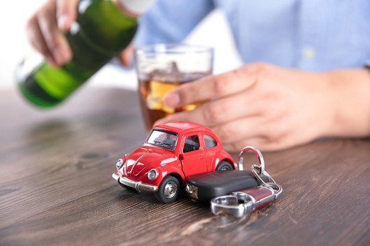 饮酒的司机和桌上汽车模型及车钥