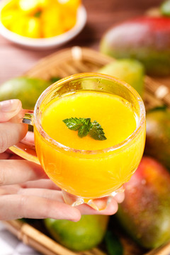 手里端着一杯芒果汁