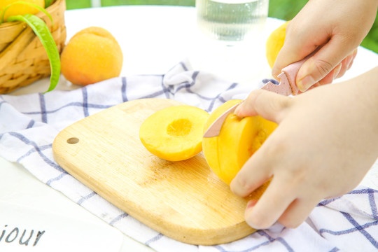 桌子上摆放着正在切的黄桃