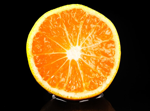 黑底上放着切开的蜜橘