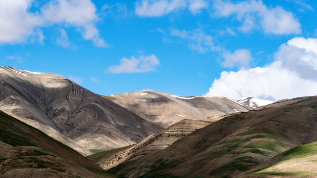 青藏高原上起伏的山体和远处的雪