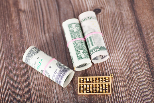 桌子上的美元钞票和金色小算珠