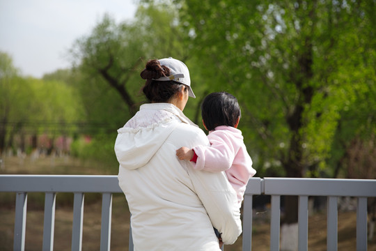 站在桥头抱着孩子的年轻妈妈