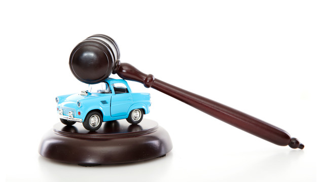 白背景上的法院法锤和小汽车模型