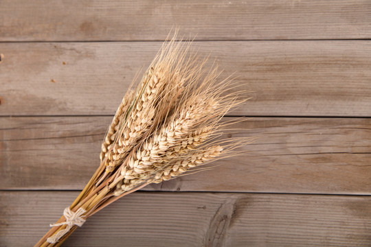 木板背景上一把成熟了的麦子