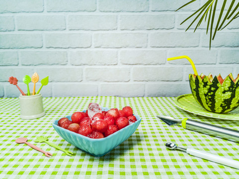 绿桌布上造型水果刀及加工的西瓜