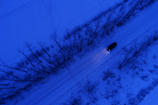 呼伦贝尔寒冬黎明雪原道路越野车