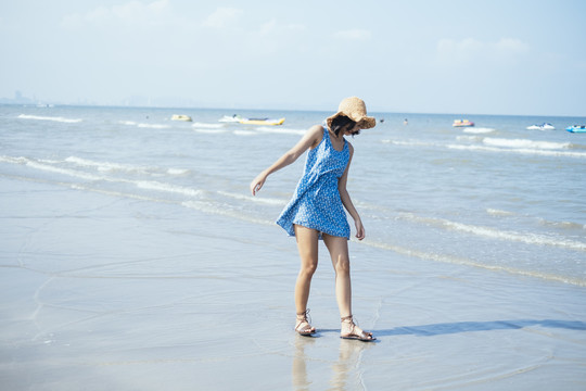 夏天，黑发可爱的女孩在海边散步。