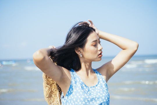 在海上刮风的日子里，黑头发的女孩摘下帽子。