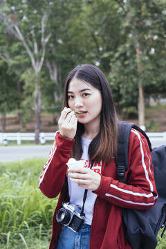 在泰国，一位女旅行者喜欢吃椰子冰淇淋。