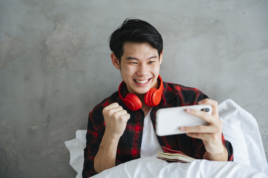 亚洲年轻人喜欢在卧室里用智能手机玩手机游戏。