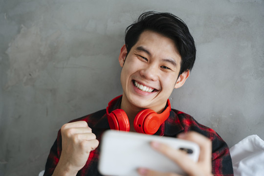亚洲年轻人喜欢在卧室里用智能手机玩手机游戏。