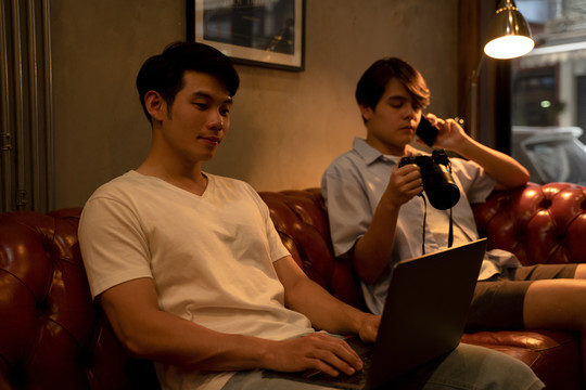 两名亚洲LGBTQ+男子在网上搜索拍照地点。