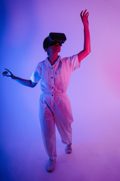 使用VR头戴式护目镜玩游戏和视频的年轻亚洲女性肖像。