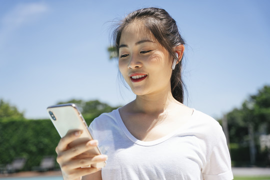 健康亚洲女性慢跑和听音乐的特写照片。