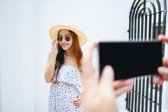 美丽的亚洲女旅行者正在用智能手机拍照。