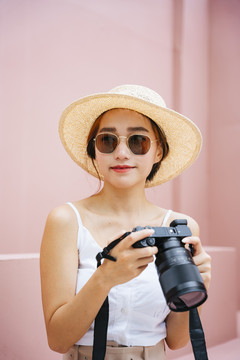 带着数码相机的年轻旅行家亚洲女人。