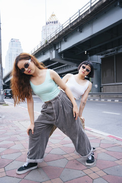 两位在街上戴太阳镜的时髦亚洲年轻女性的肖像。