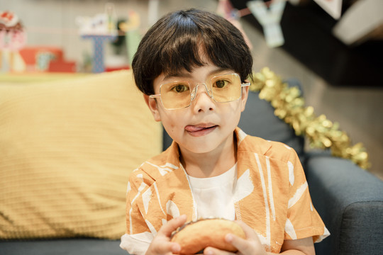 一个男孩戴着眼镜和夹克舔嘴唇的特写照片。
