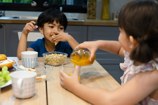 兄弟姐妹上学前在厨房吃早餐。