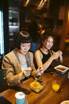 年轻的亚洲女商人在现代化的办公室里休息，一起吃午餐。
