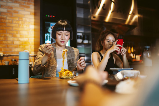 年轻的亚洲女商人在现代化的办公室里休息，一起吃午餐。