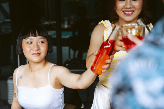 亚洲人和朋友在聚会上用酒杯和酒瓶敬酒。