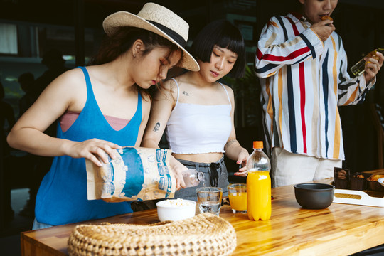 年轻游客在派对开始前准备点心和饮料。