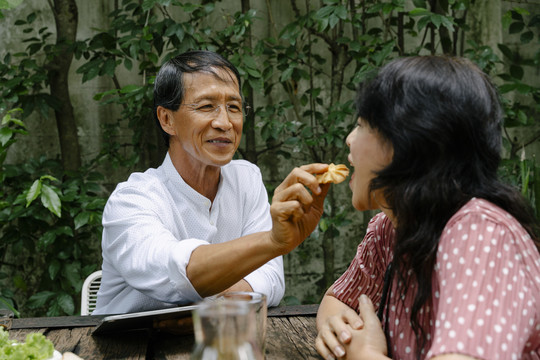 亚洲老夫妇喜欢在后院一起吃甜点饼干。