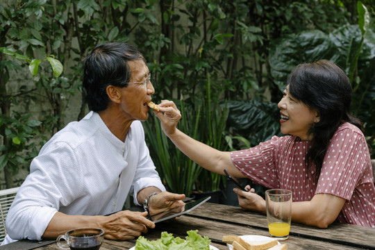 亚洲老夫妇喜欢在后院一起吃甜点饼干。