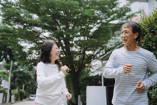 快乐的亚洲老年夫妇在公园户外慢跑锻炼。