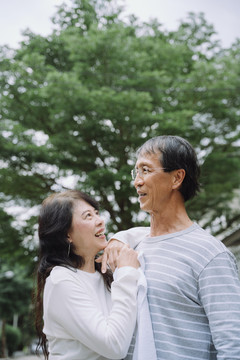 亚洲老夫妇在公园里幸福地拥抱。