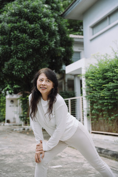 亚洲健康老妇人在运动前伸展身体和热身的肖像。