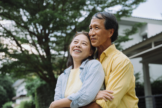 亚洲老年夫妇在后院室外拥抱的肖像。