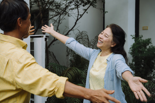 亚洲老年夫妇回家后拥抱他们的爱人。