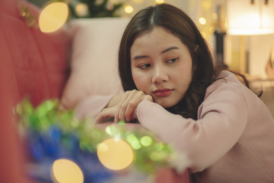 年轻的亚洲美女黑发独自在房间里庆祝圣诞派对。