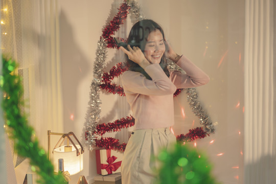 美丽的亚洲年轻女子黑头发喜欢在家里的圣诞晚会上跳舞。