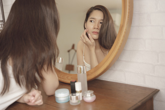 年轻的亚洲美女脸上有痤疮问题。女性概念的面部问题。