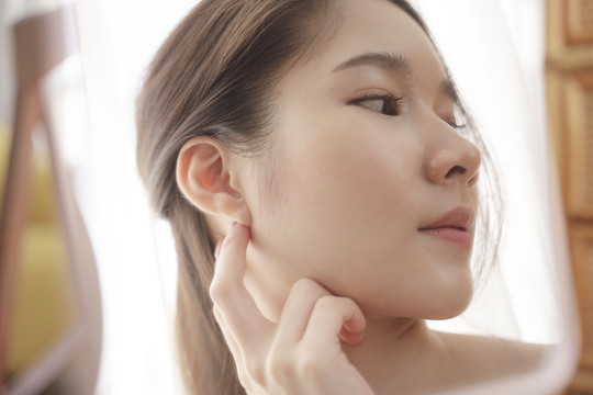 侧视图-年轻的亚洲美女模特展示左耳模型耳环。