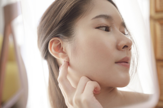 側(cè)視圖-年輕的亞洲美女模特展示左耳模型耳環(huán)。