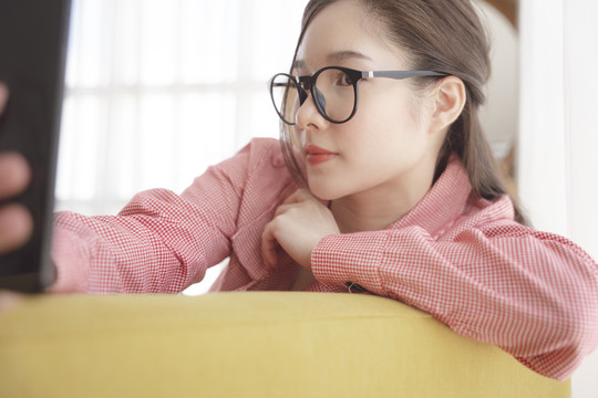 年轻亚洲美女用智能手机自拍的特写照片。