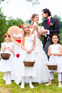 新娘和新郎与花童或伴娘以及和平的白鸽结婚