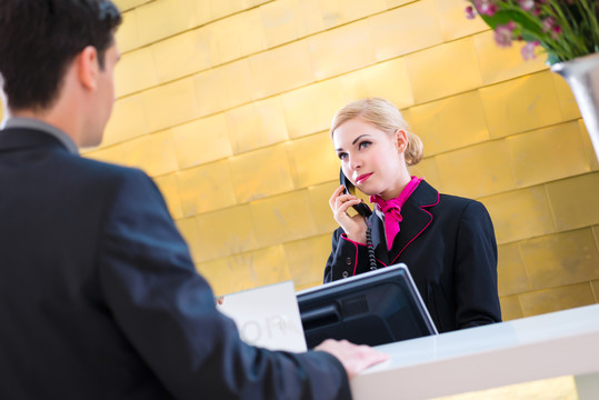 酒店接待员通过电话向客人询问预订或信息