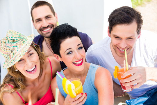 一群男女朋友在沙滩酒吧喝鸡尾酒